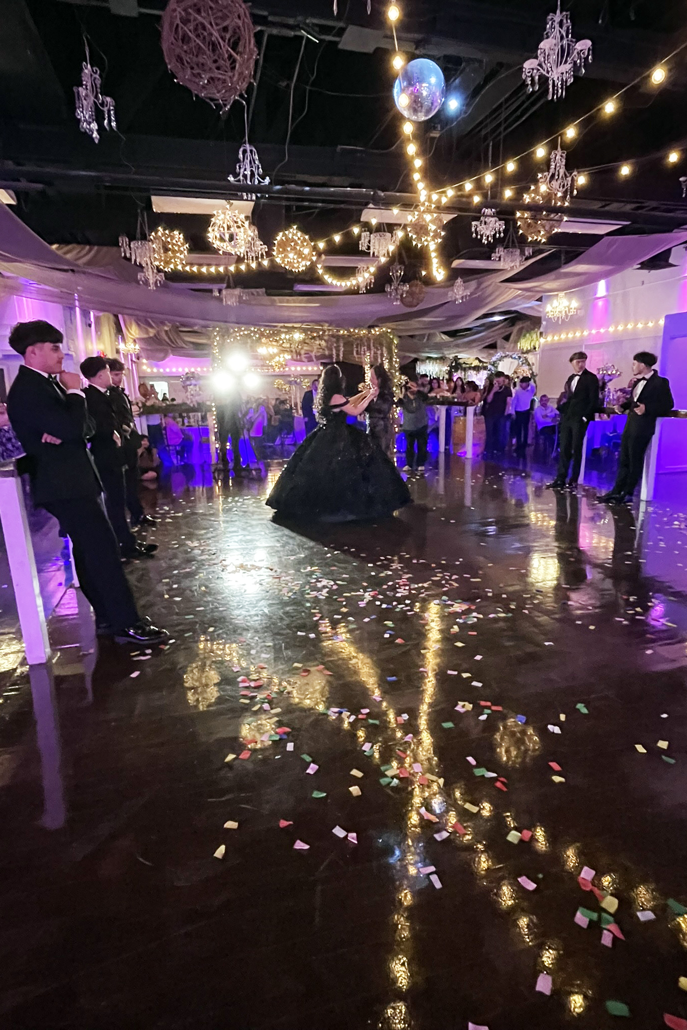 Dance floor with accent lights, twinkle lights, a mirrored ball and a beautiful polished dance floor.