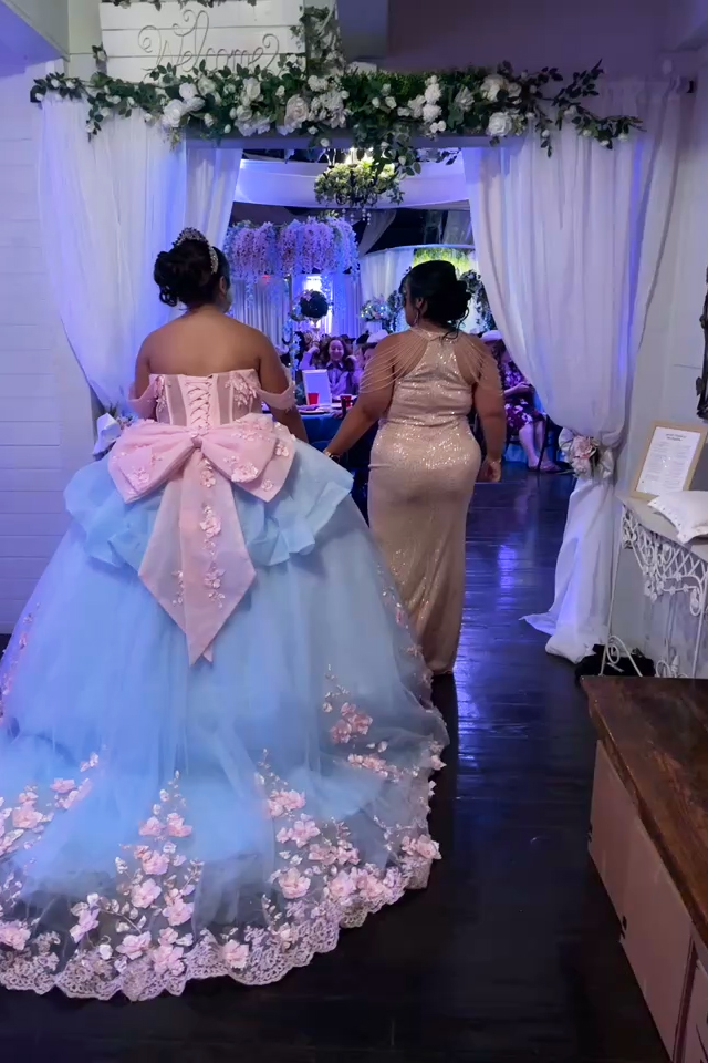 Quinceañer girl with mother making her entrance in her dress with a huge pink bow that matched her theme of bows everywhere.