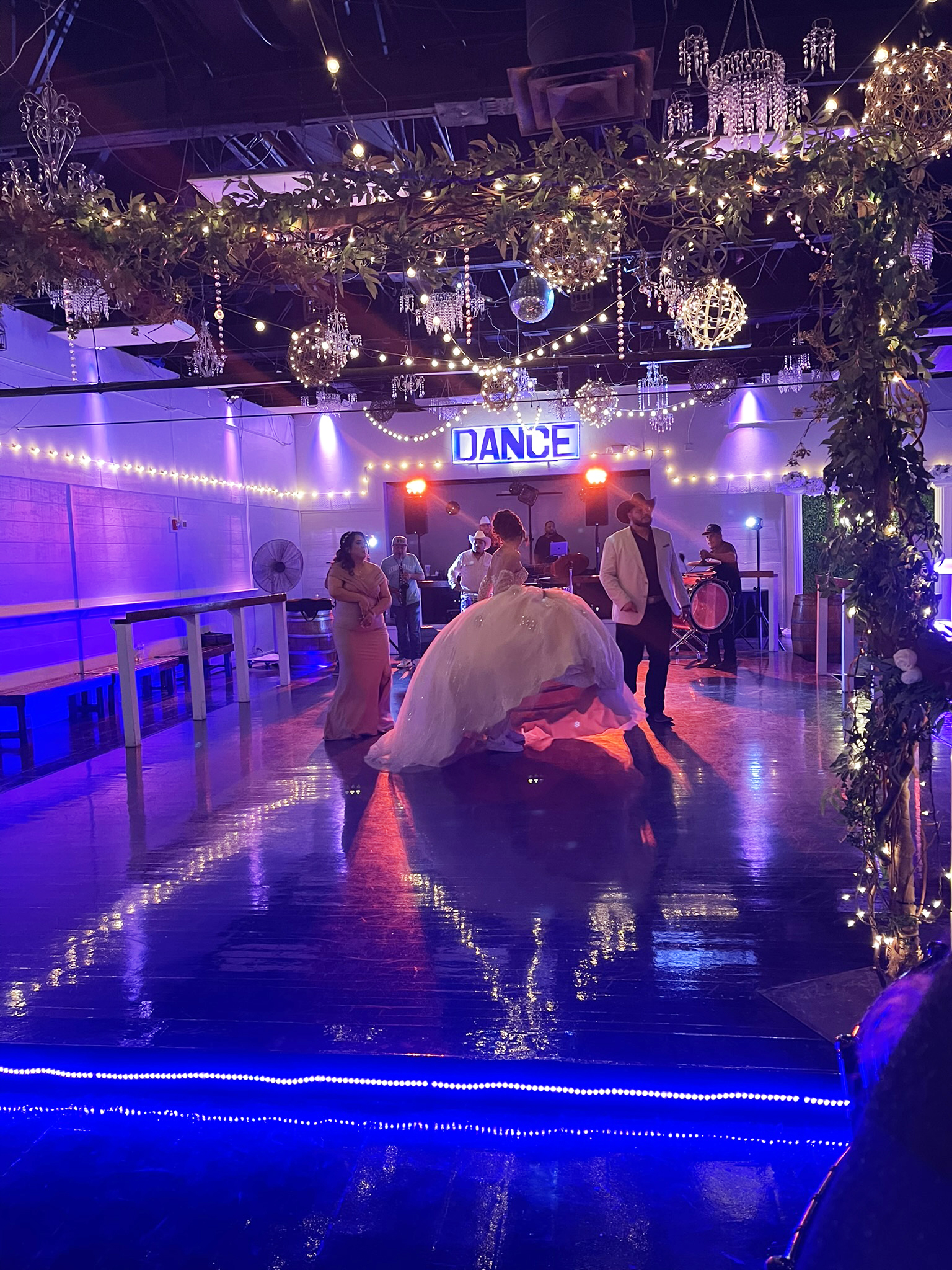 Quince girl enjoying her father - daughter dance on illuminated dance floor.
