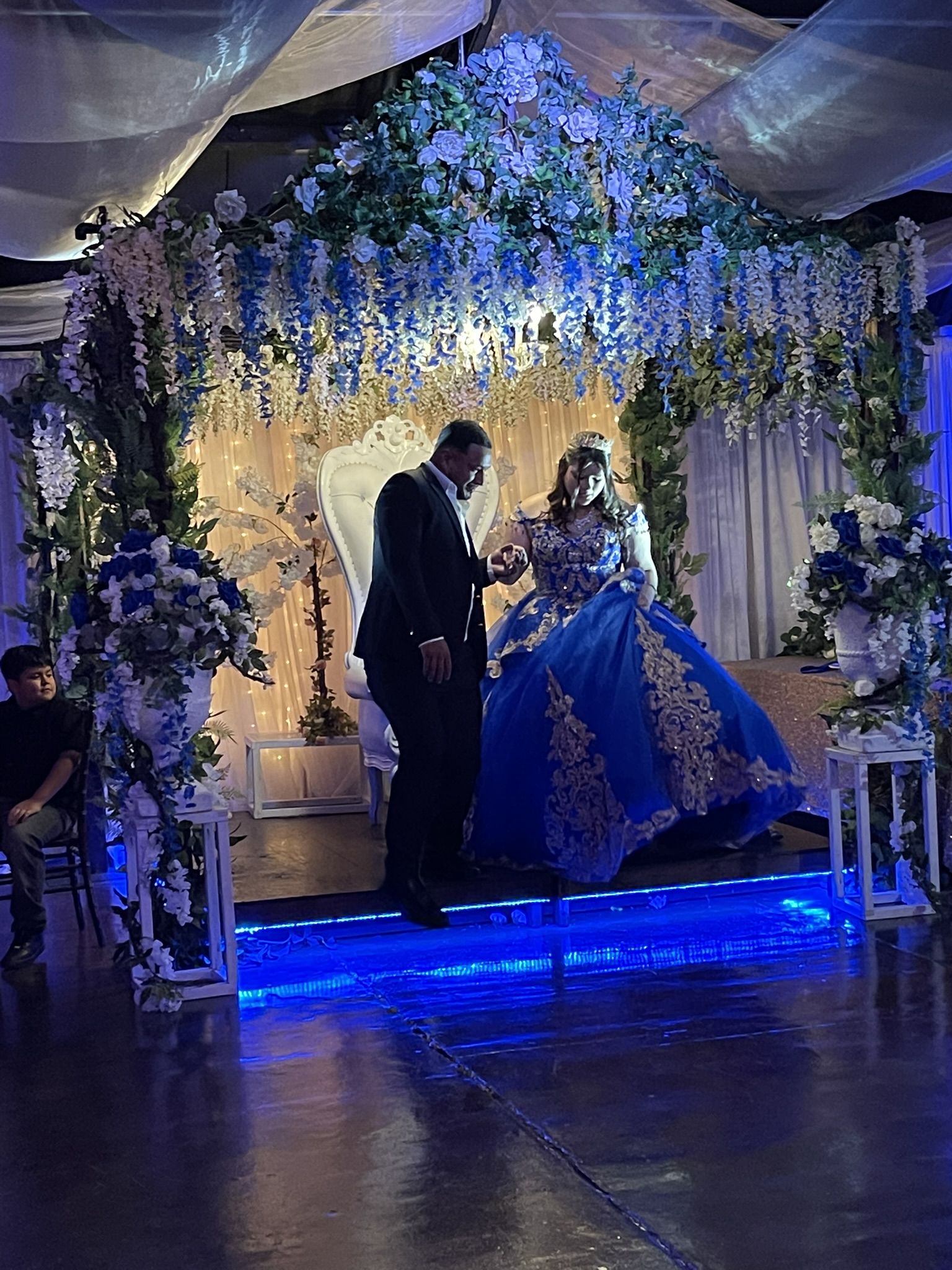 Father escourting his daughter to the dance floor for a father-daughter dance.