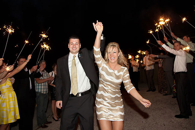 Bride and groom farewell under portaco with sparkler exit.