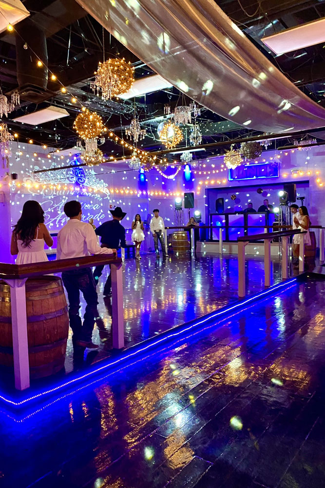 Dancers out on the lluminated dance floor filled with specialty lights.