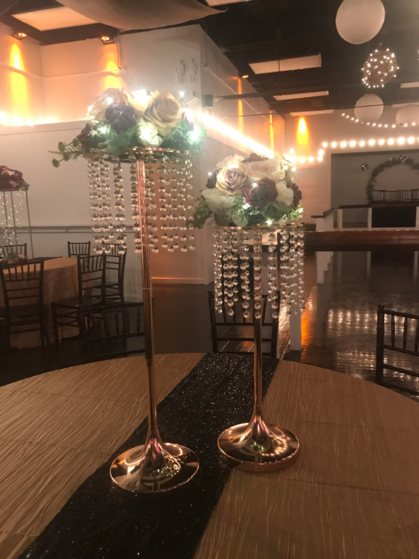 Tall statement gold centerpiece with florals and greenery for a dramatic event table display at The Chateau at Forest Park