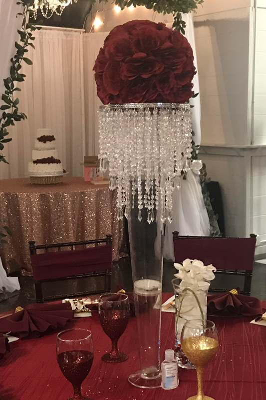 Tall modern glass trumpet centerpiece with lighting accents for an elegant event table at The Chateau at Forest Park
