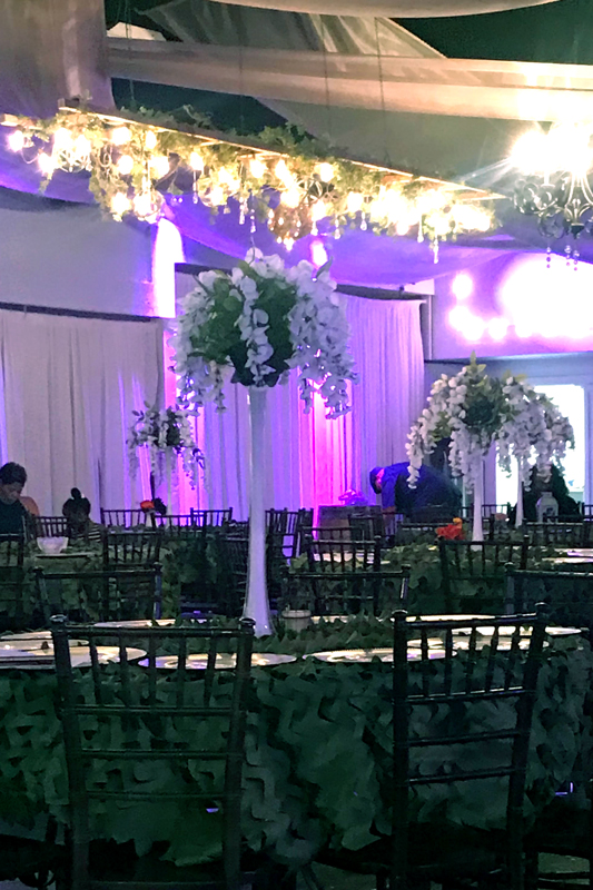 Tall milk glass centerpiece with florals and greenery for a dramatic event table display at The Chateau at Forest Park