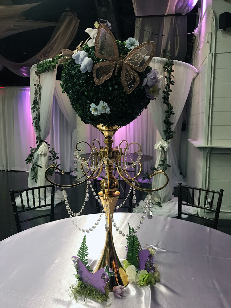 Tall statement centerpiece with florals and greenery for a dramatic event table display at The Chateau at Forest Park