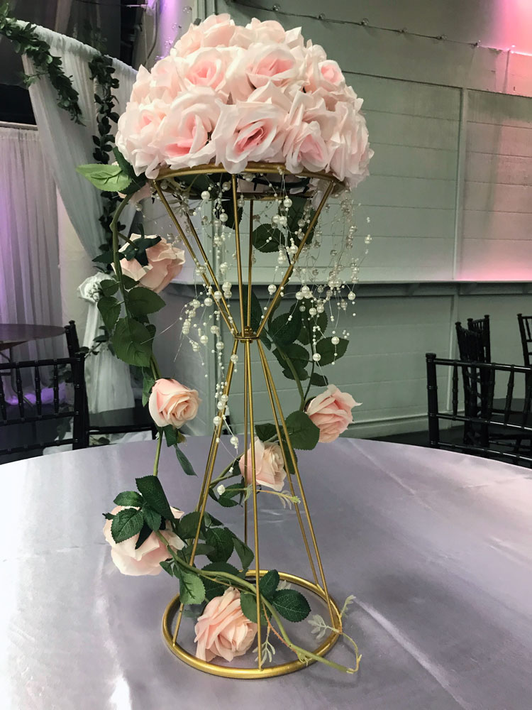 Tall statement centerpiece with florals and greenery for a dramatic event table display at The Chateau at Forest Park