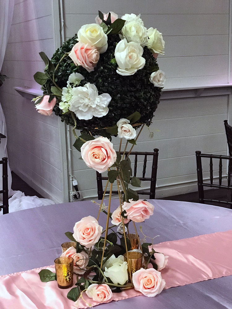 Tall statement centerpiece with florals and greenery for a dramatic event table display at The Chateau at Forest Park