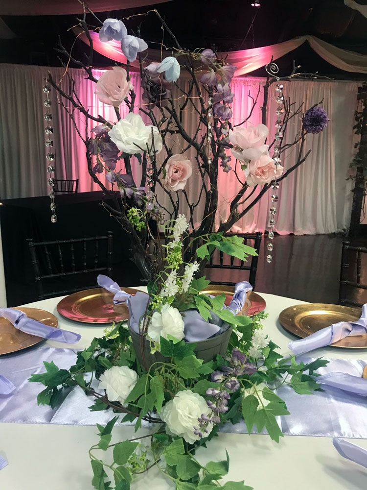 Rustic branch centerpiece with natural wood elements and greenery at The Chateau at Forest Park