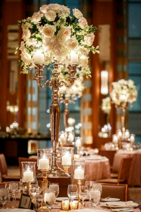 Tall candelabra centerpiece with florals and greenery for a dramatic event table display at The Chateau at Forest Park