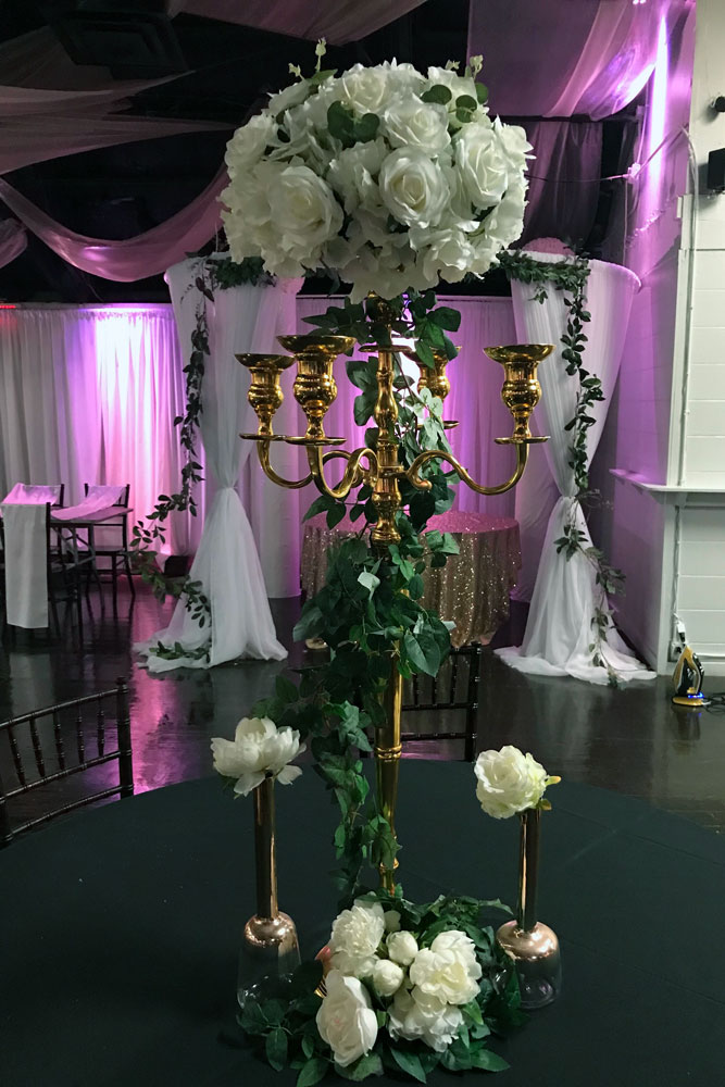Gold candlabra centerpiece with floral accents for a formal wedding reception at The Chateau at Forest Park
