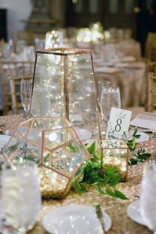 Gold lantern centerpiece with soft lighting and greenery for wedding or event tables at The Chateau at Forest Park