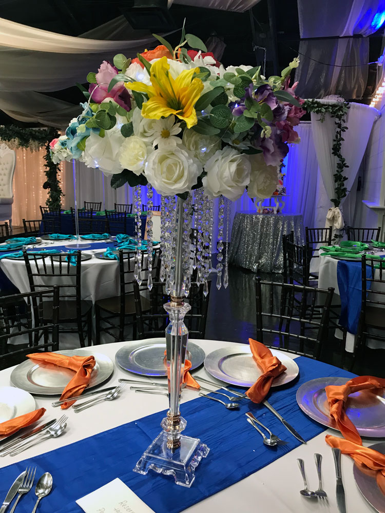 Tall candelabra centerpiece with florals and greenery for a dramatic event table display at The Chateau at Forest Park