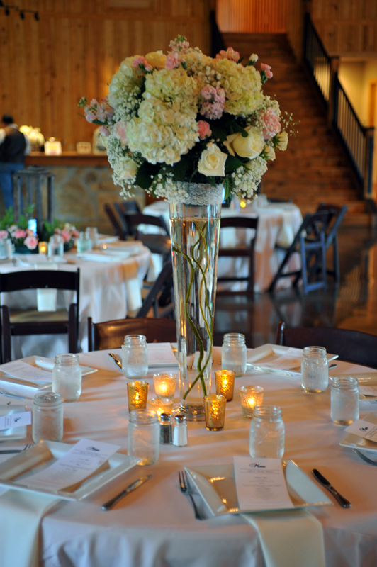 Modern glass tulip centerpiece with lighting accents and greenery for an elegant event table at The Chateau at Forest Park