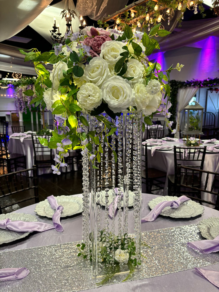 Tall statement centerpiece with jewels, florals and greenery for a dramatic event table display at The Chateau at Forest Park