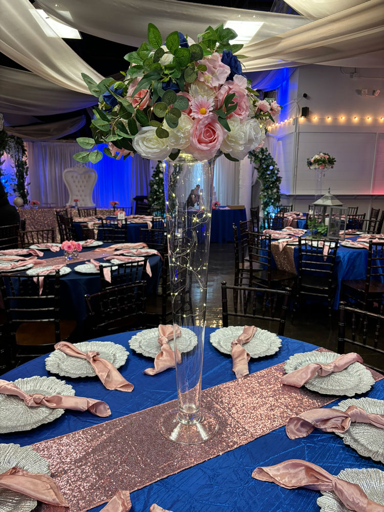 Tall statement centerpiece with jewels, florals, and greenery for a dramatic event table display at The Chateau at Forest Park