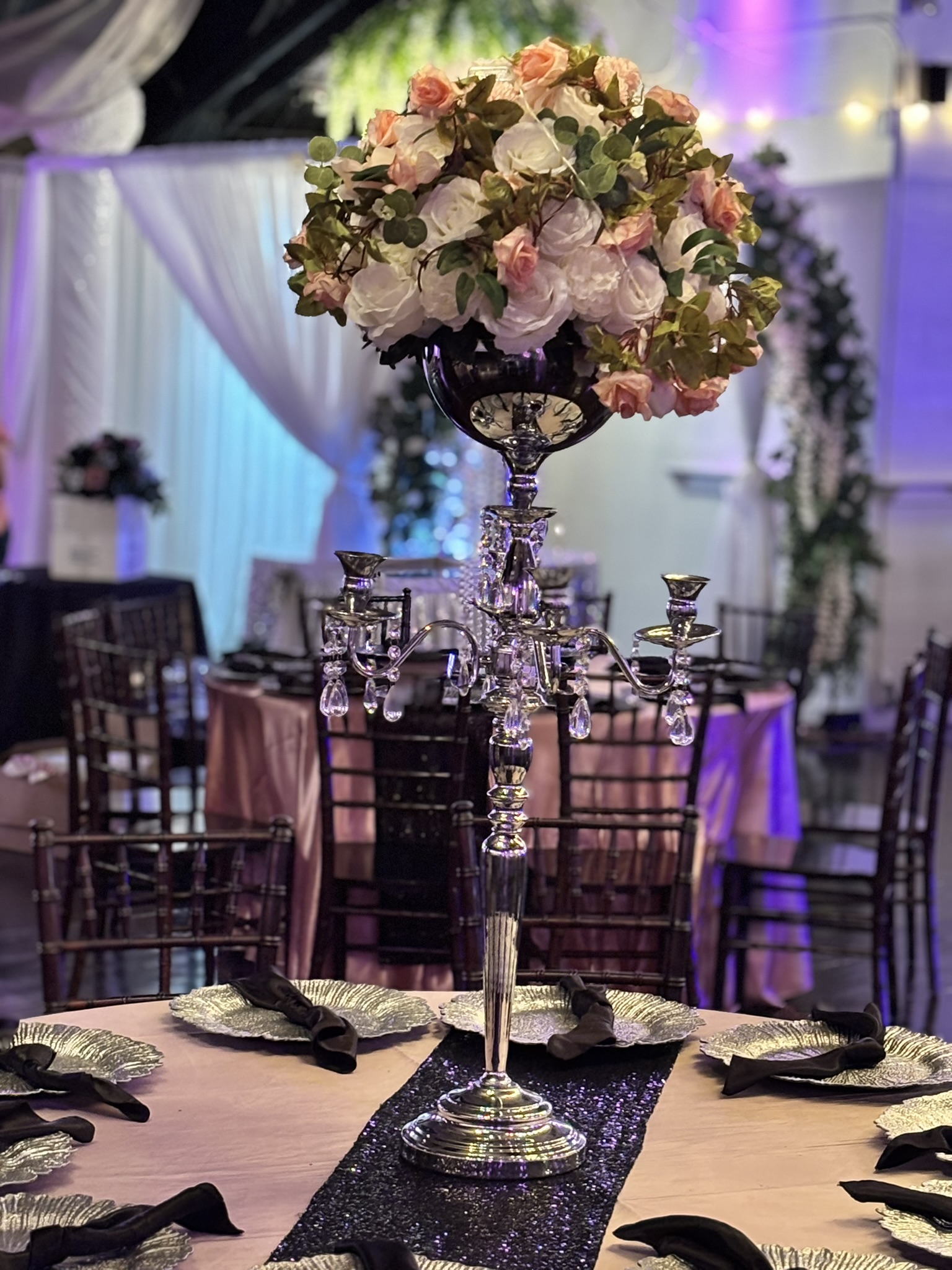 Tall candelabra statement centerpiece with florals and greenery for a dramatic event table display at The Chateau at Forest Park