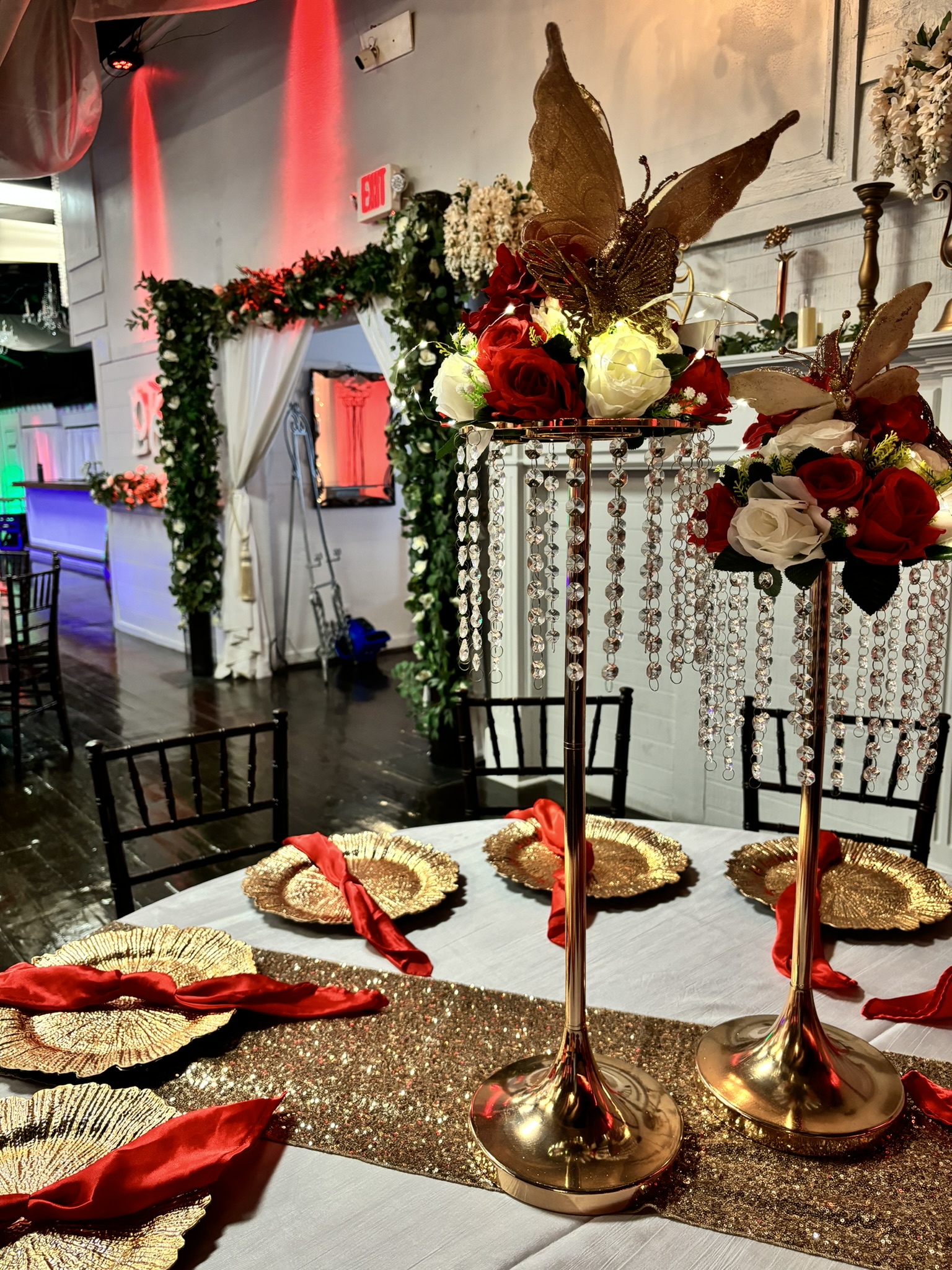 Tall gold statement centerpiece with butterflies, jewels, and florals for a dramatic event table display at The Chateau at Forest Park