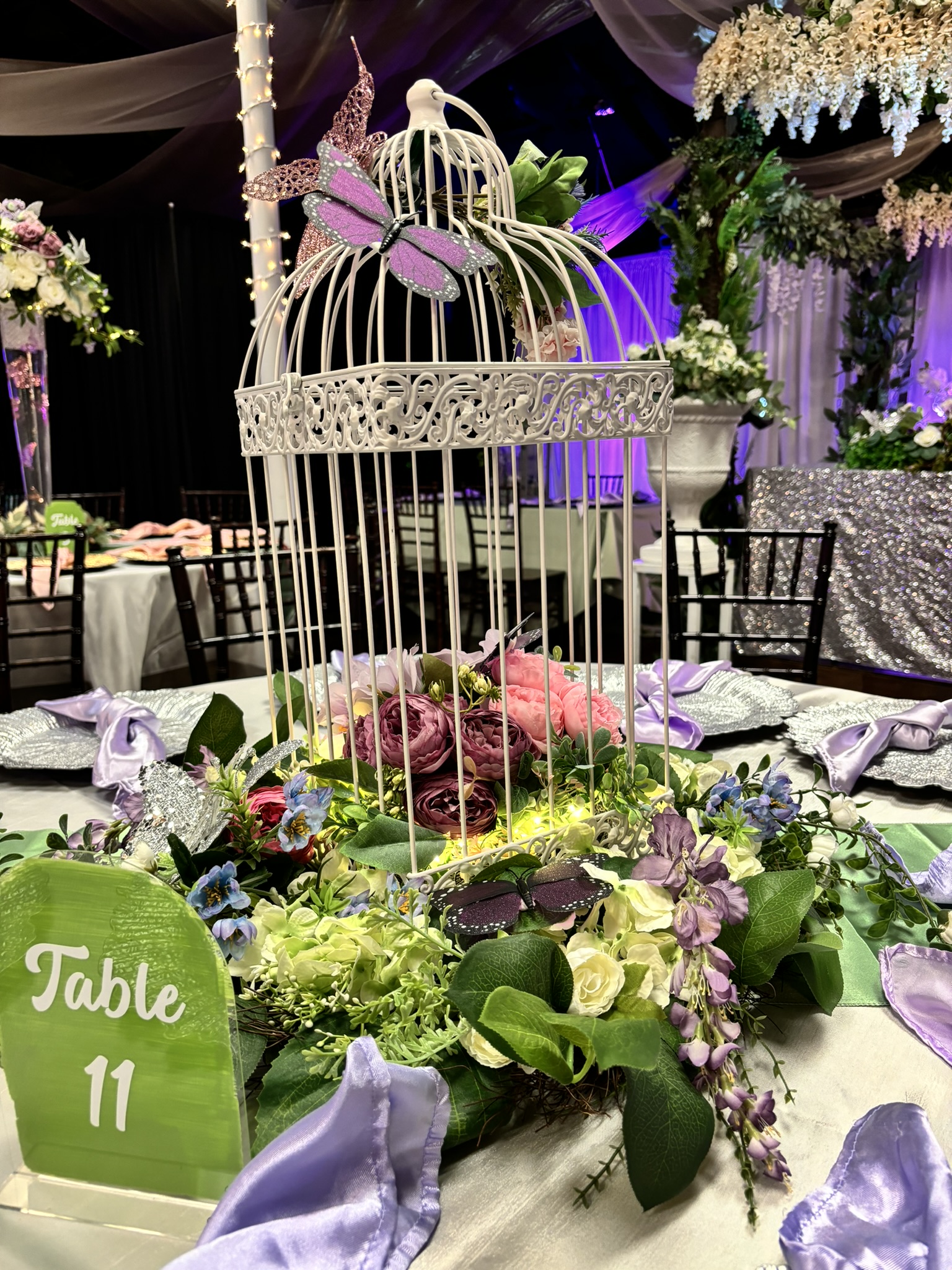 Bird cage centerpiece with soft lighting and greenery for wedding or event tables at The Chateau at Forest Park