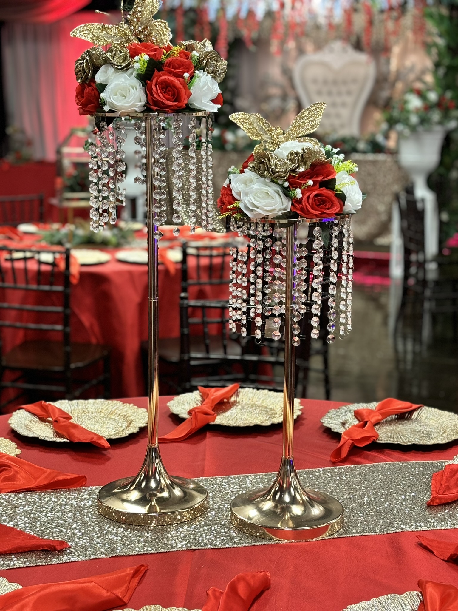 Tall gold fram centerpiece with jewels, florals, and greenery for a dramatic event table display at The Chateau at Forest Park