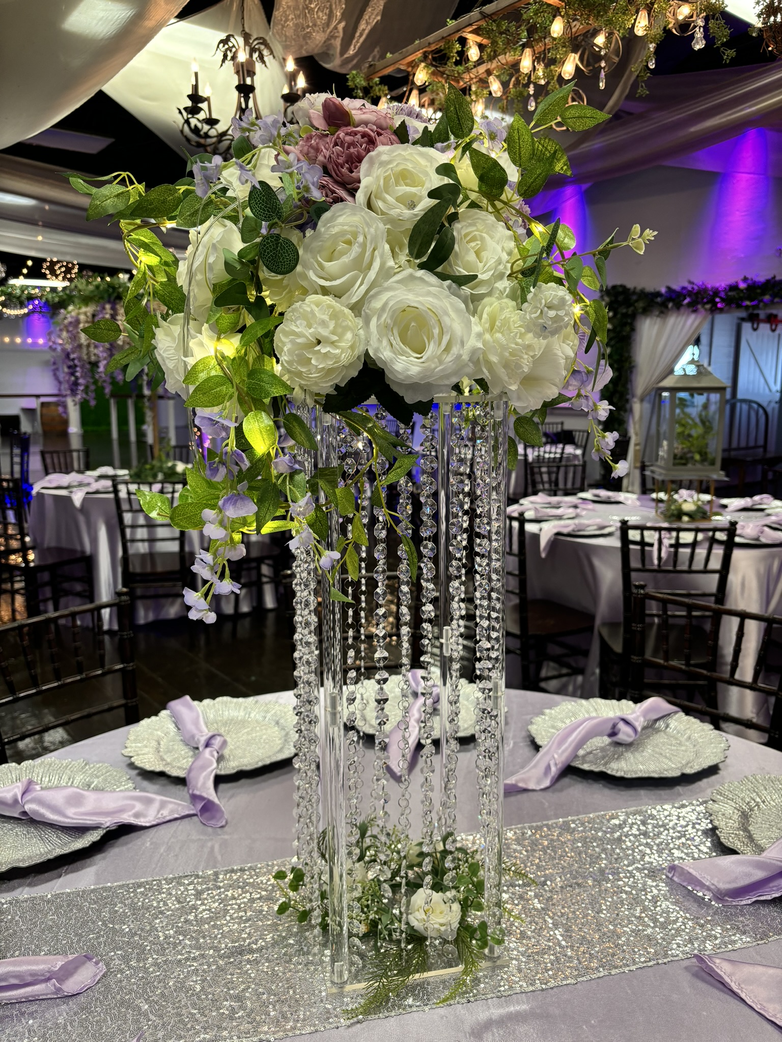 Tall jeweled statement centerpiece with florals and greenery for a dramatic event table display at The Chateau at Forest Park