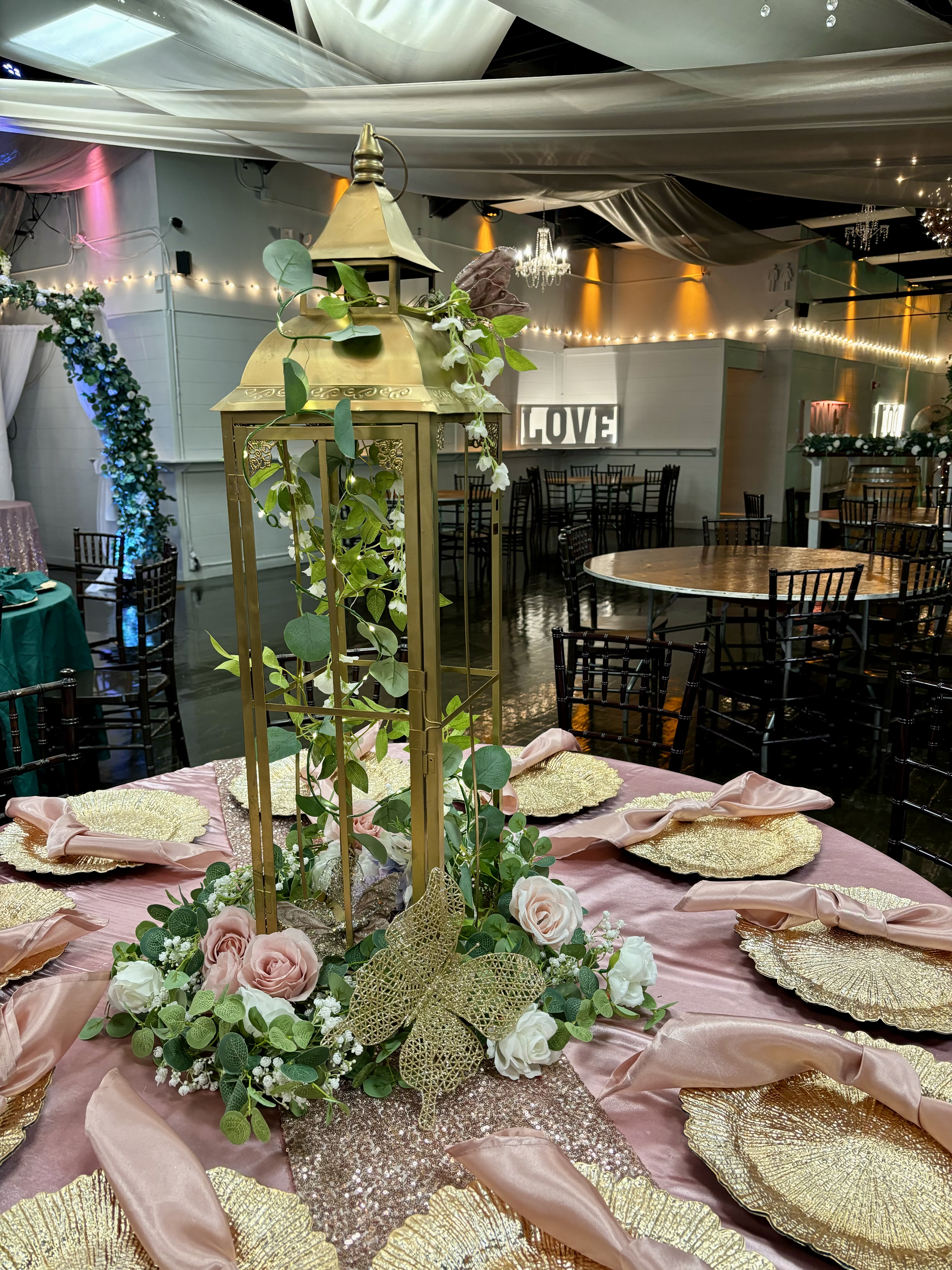 Gold lantern centerpiece with flowers, greenery and more at the Chateau event venue