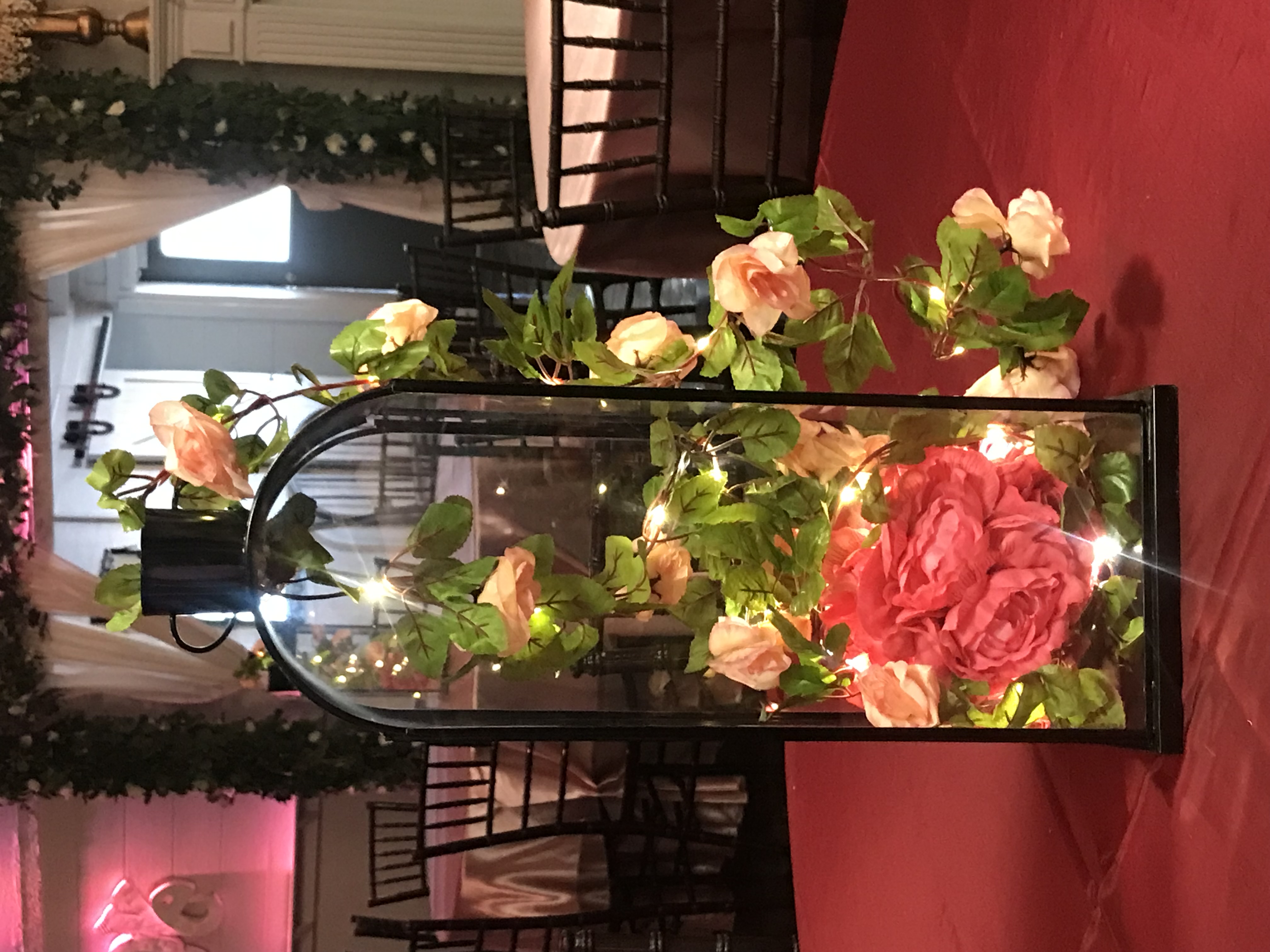 Black lantern centerpiece with twinkle lights, flowers, and greenery at the Chateau event venue