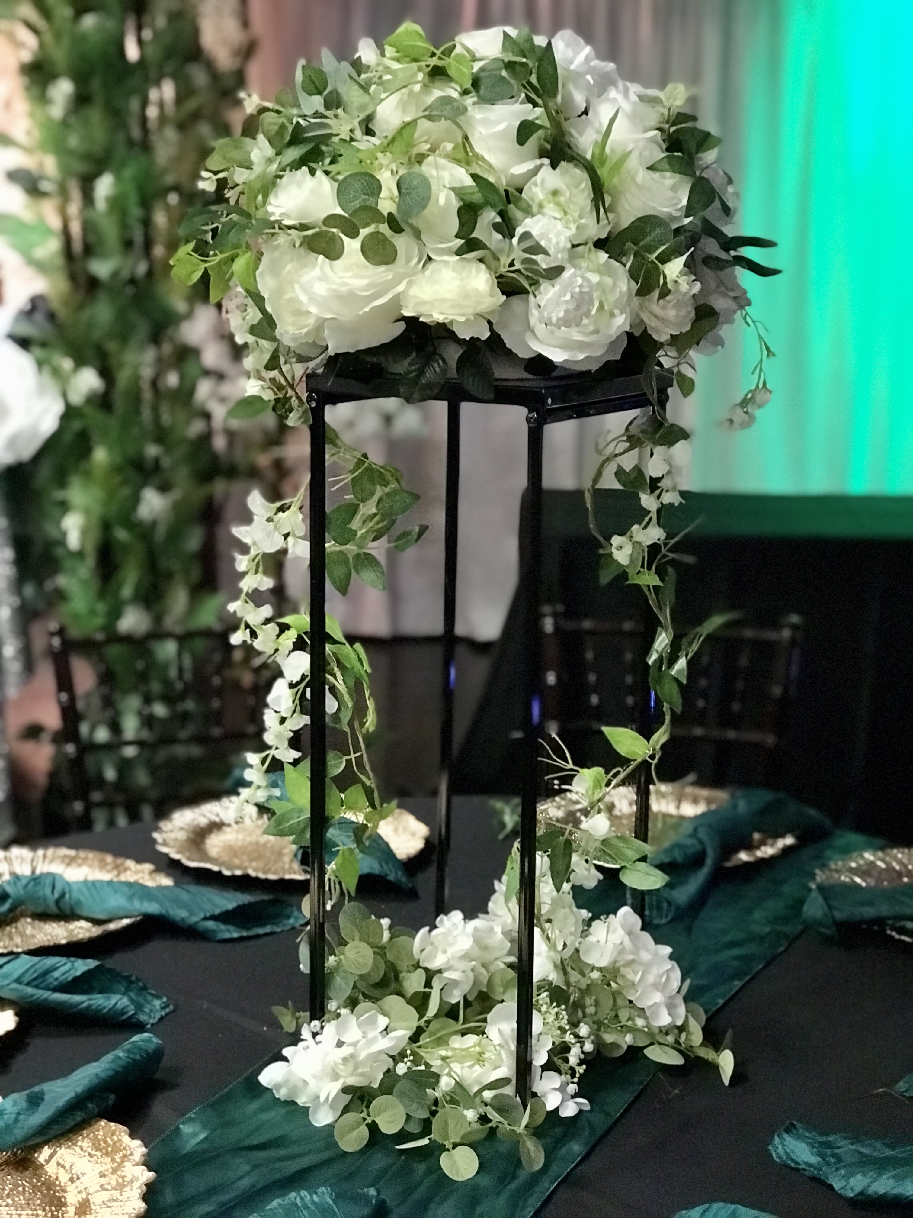 Modern tall black frame glass lantern centerpiece with flowers, greenery and more at the Chateau event venue