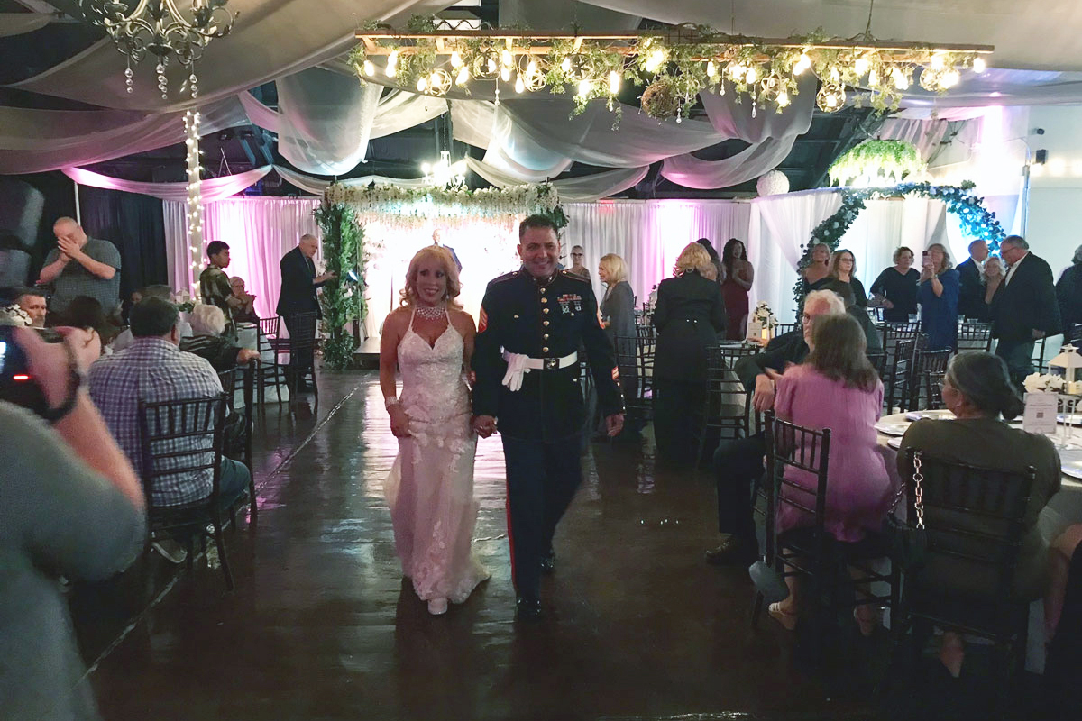 Bride and groom standing together beneath a garden gazebo during their wedding ceremony