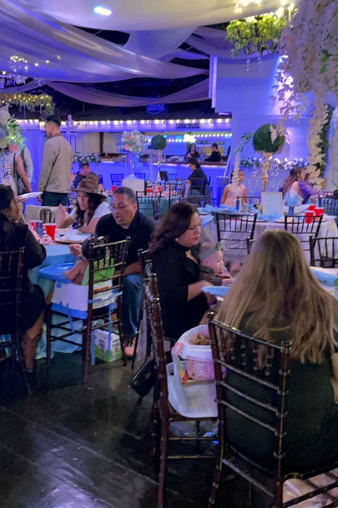 Elegant reception dining setup with guests seated for dinner inside the ballroom at an event venue