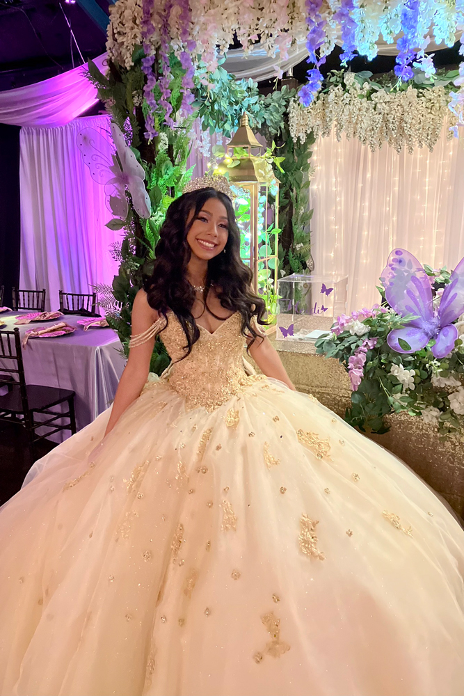 Quinceañer girl in dress with matching decor in a celebration moment
