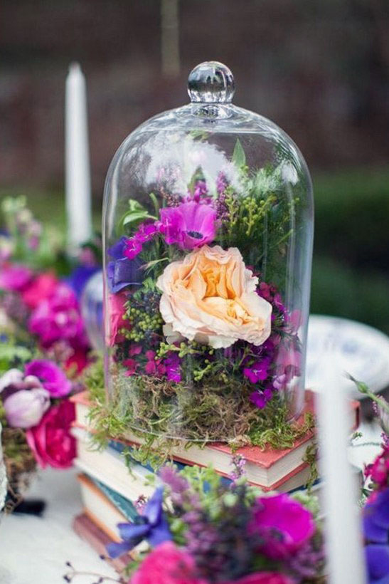 Elegant woodland-accented table centerpiece with candlelight and red roses