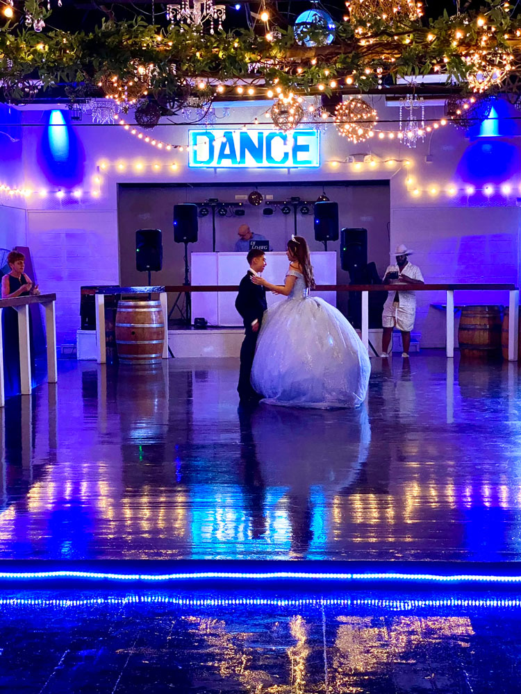 Dance floor framed by blue-toned lighting and coordinated reception decor