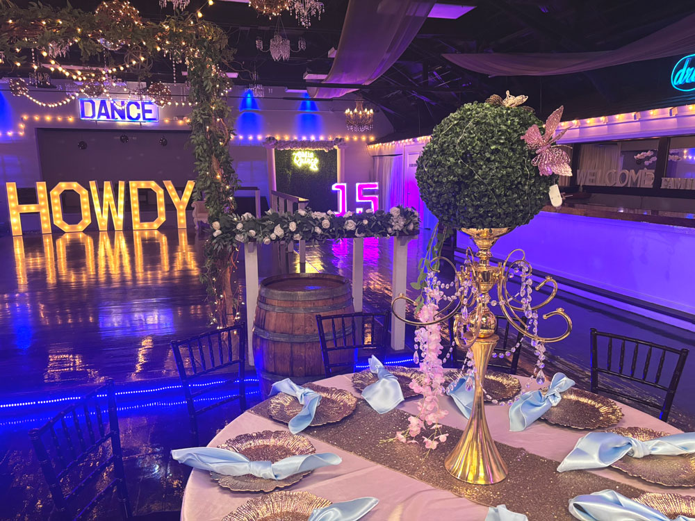 Guest table and dance floor illuminated by soft blue lighting for a romantic celebration atmosphere