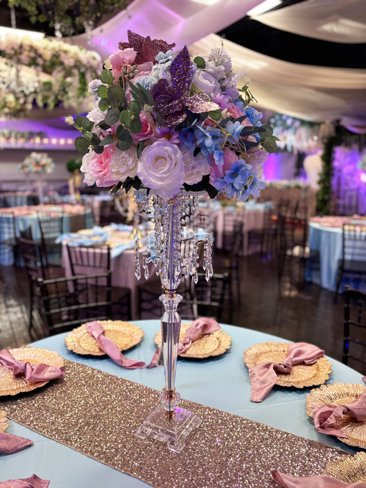 Reception centerpiece designed with layered pastel & blue hues and soft candlelight