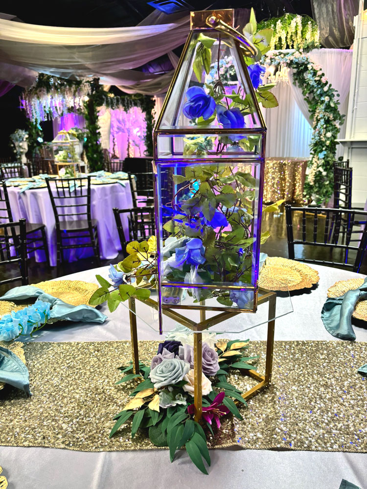 Table w lantern centerpiece featuring blue florals and elegant floral accents