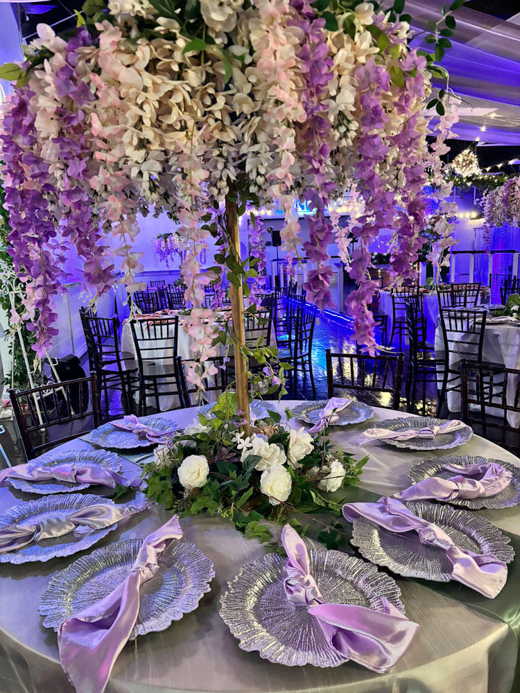 Whimsical quinceañera centerpiece design with butterfly elements, floral accents, and accent lighting