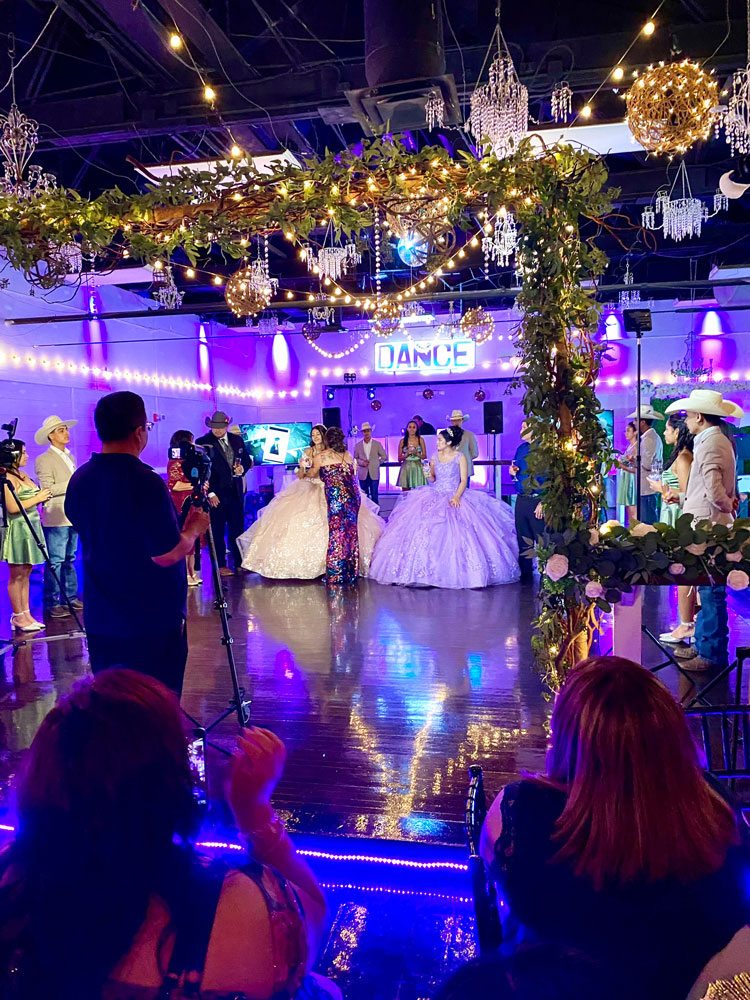 Butterfly-themed quinceañera dance floor with colorful lighting and guests celebrating