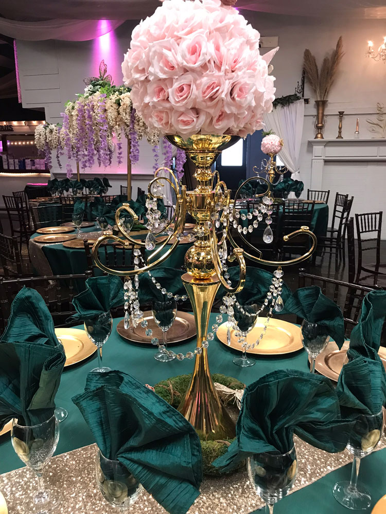Forest-inspired chandelier centerpiece combining greenery, texture, and soft glow