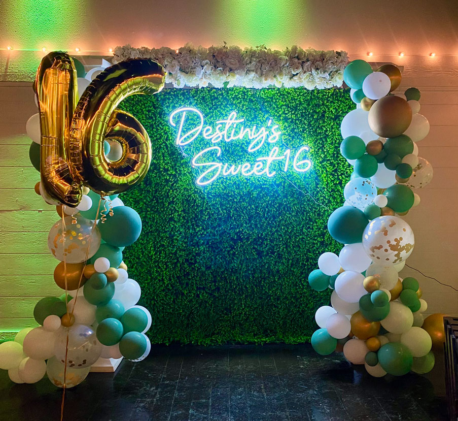 Elegant photo op area decorated wwith balloons in soft sage and emerald green tones