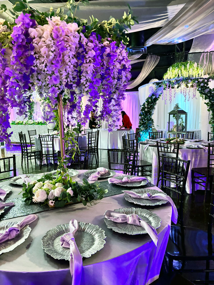 Elegant table centerpiece featuring lavender flowers, greenery and crystal details