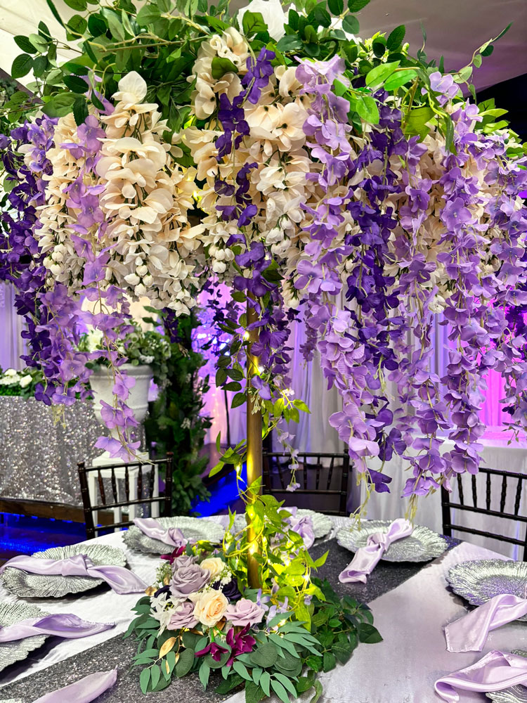 Purple floral centerpiece with floral and greenery accents on a formal dining table