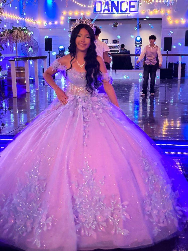 Quince girl ready for father-daughter on a dance floor illuminated with romantic purple lighting