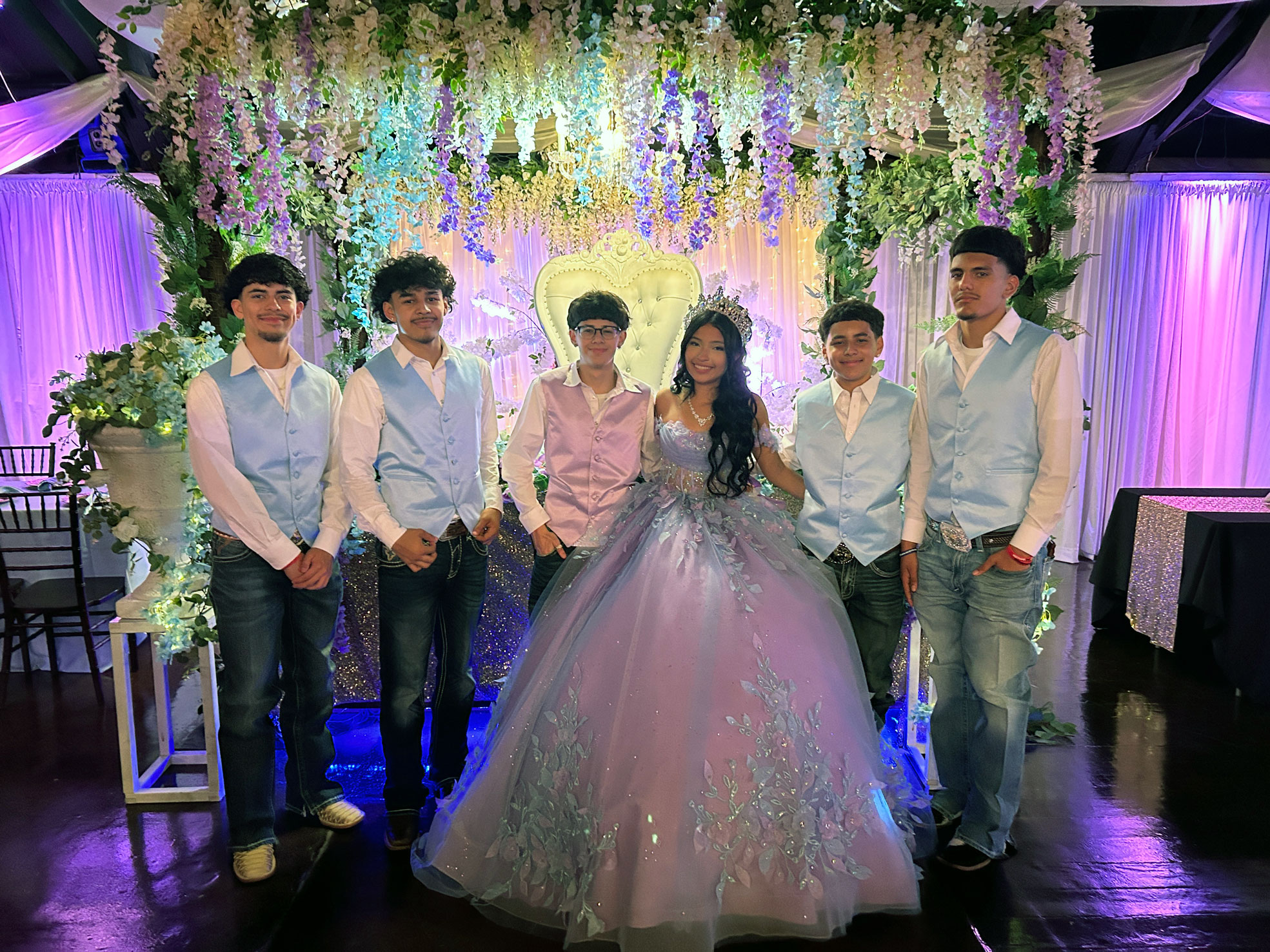 Quince girl with friends sharing a photo moment under soft purple uplighting