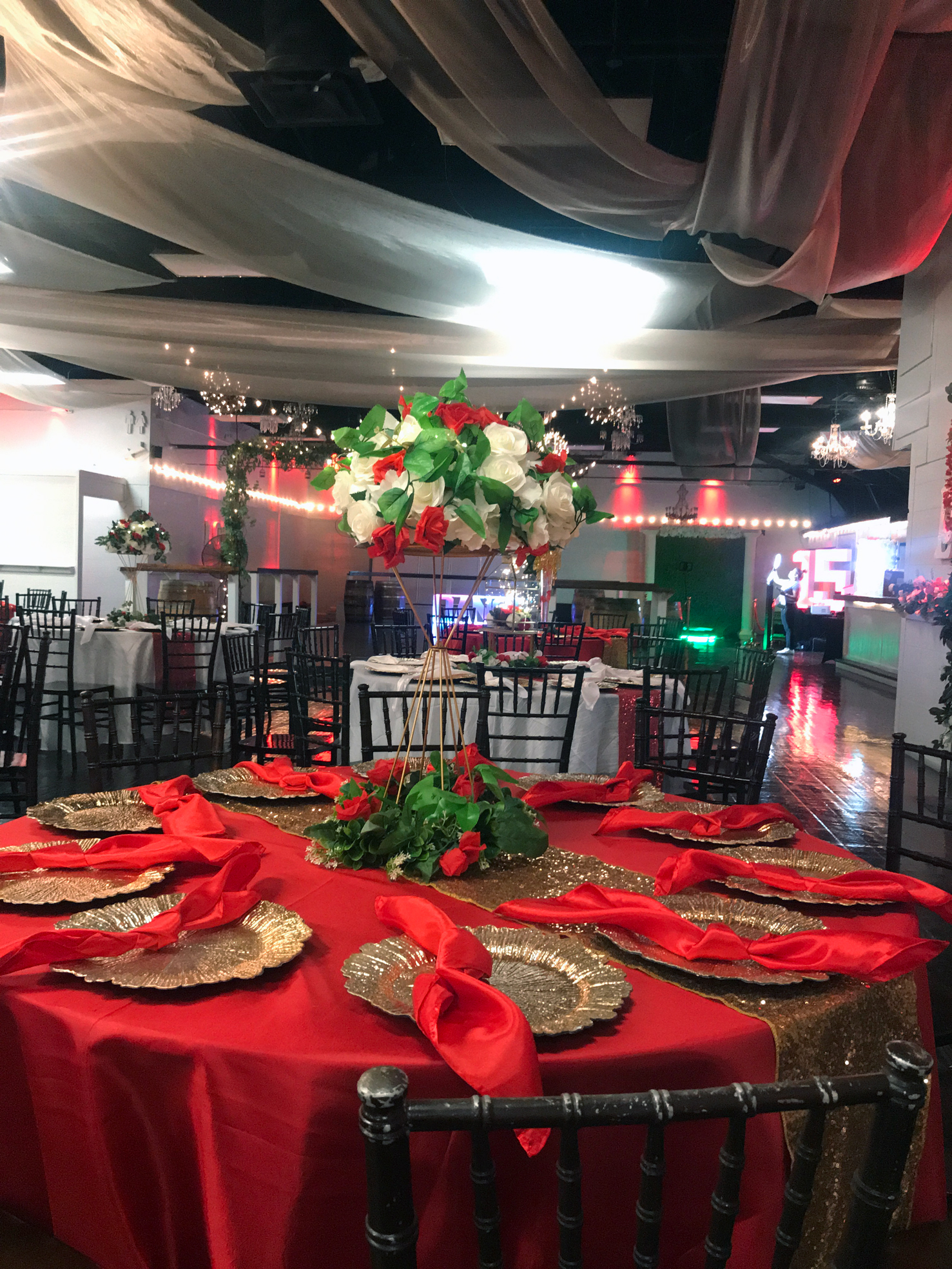 Guest table jeweled and floral centerpiece styled in layered shades of red