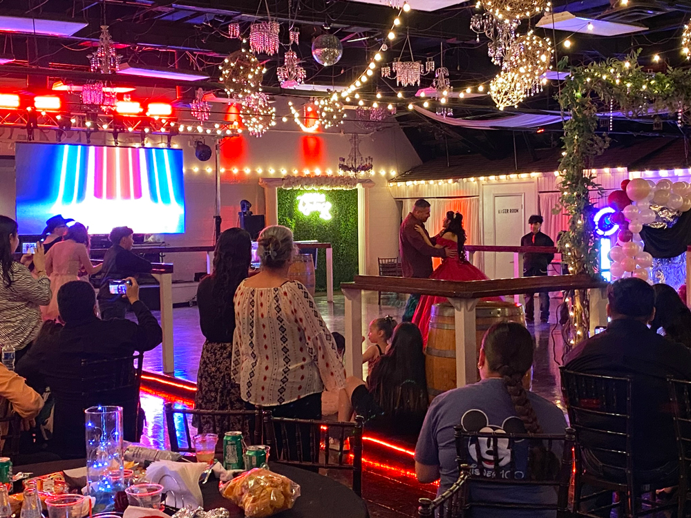 Father/daughter dance on dance floor off the main ballroom with soft red uplighting creating a romantic atmosphere